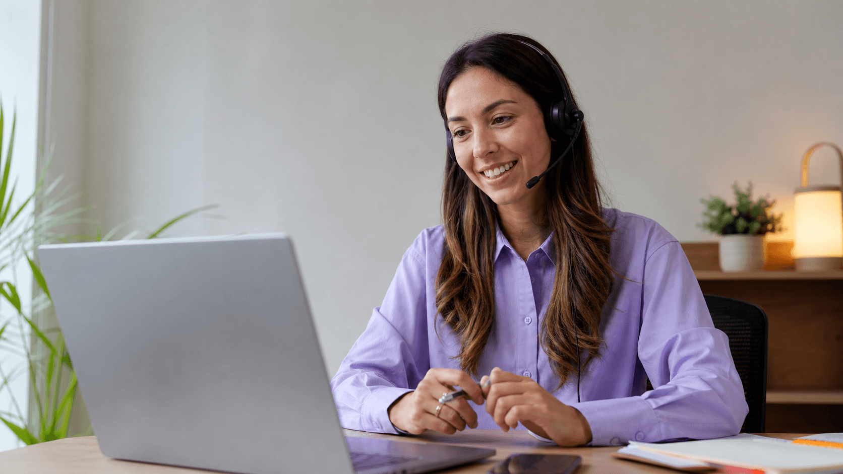Profissional de atendimento conversando com uma pessoa pelo computador